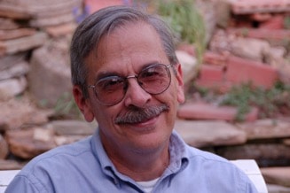 A person wearing glasses and smiling at the camera

Description automatically generated